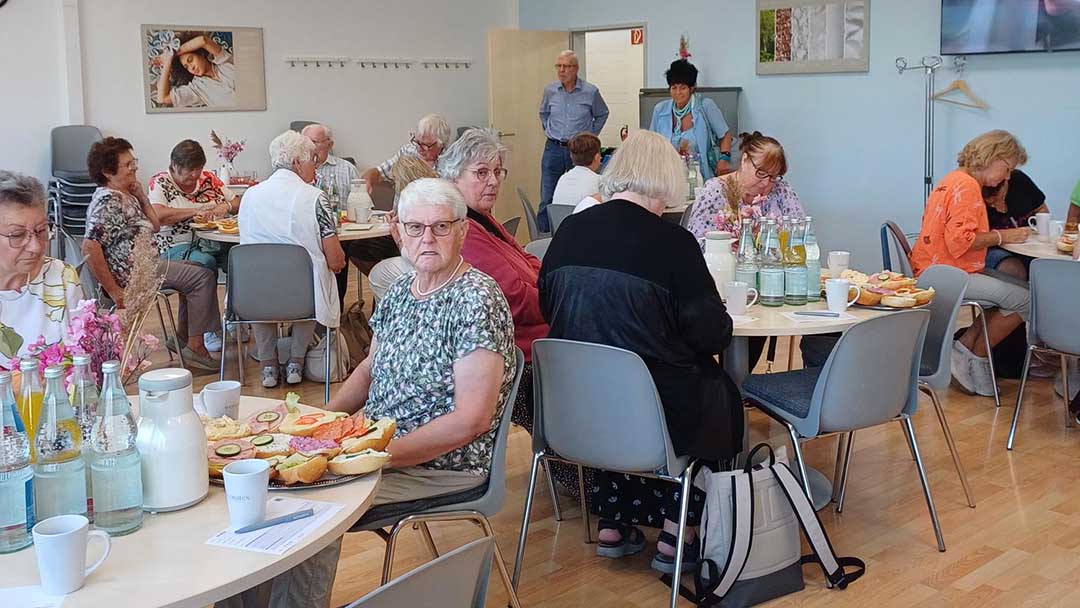 Menschen sitzen an Tischen und schreiben.